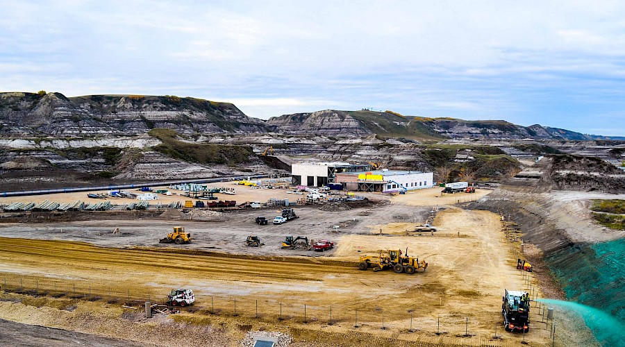 A bird's eye view of the construction site for ATCO electric with large, rocky hills in the background.