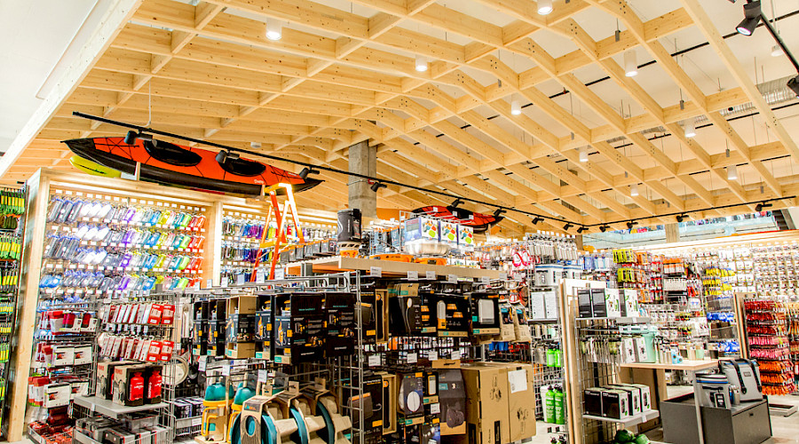 Shelves of products in the MEC store with two kayaks hanging from the ceiling.