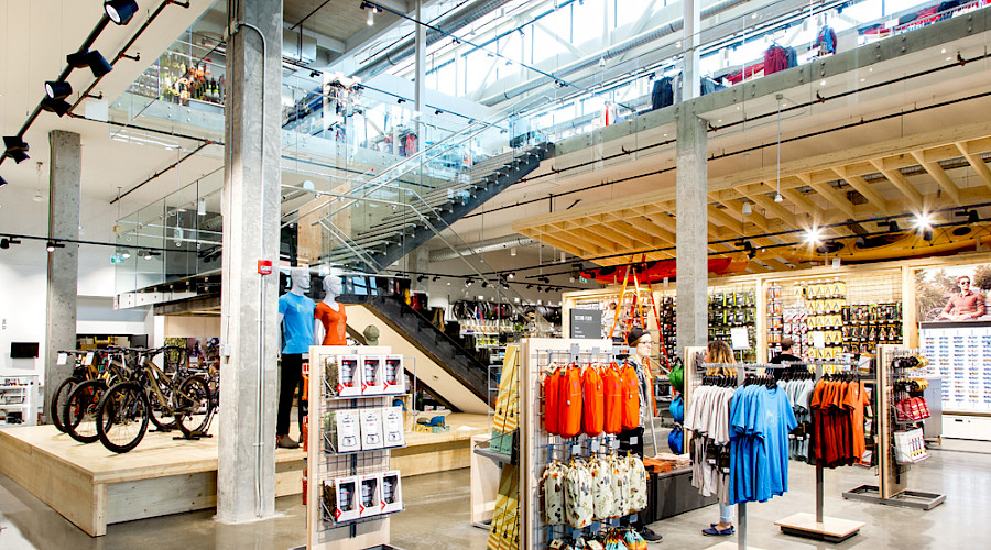 Inside of the MEC store filled with products with a staircase leading up to the second floor.