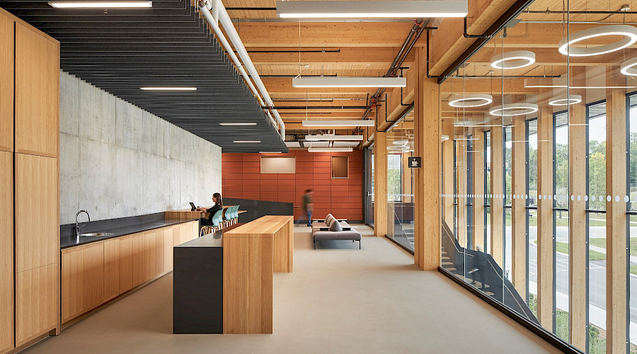 Interior shot of the Science Collaboration Centre collaboration space, with neutral earthy colours, kitchen, work spacess, built by Chandos Construction Ottawa