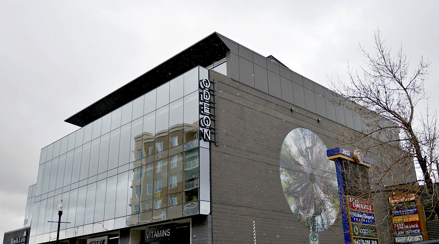 A corner shot of the Odeon commercial property featuring a mural on one wall on a cloudy grey day.