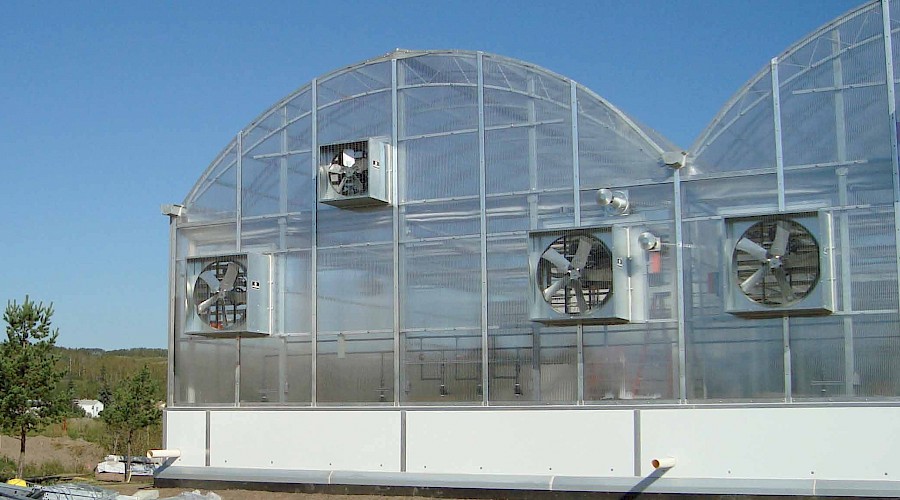 Fans on the outside of a large greenhouse.