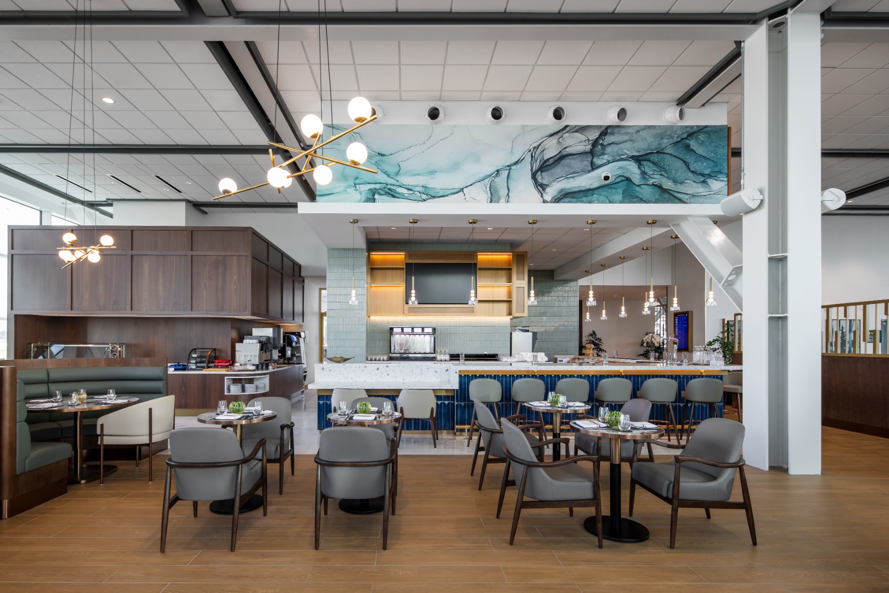 Interior image of the new YVR Plaza Premium Lounge, featuring custom millwork, luxury furniture, and an open concept style breakfast bar kitchen.