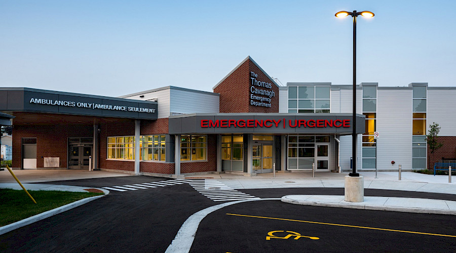 Exterior shot of the Carleton Place and District Memorial Hospital emergency wing built by Chandos Construction Ottawa, with large red lettering, white paneling, and red bricks