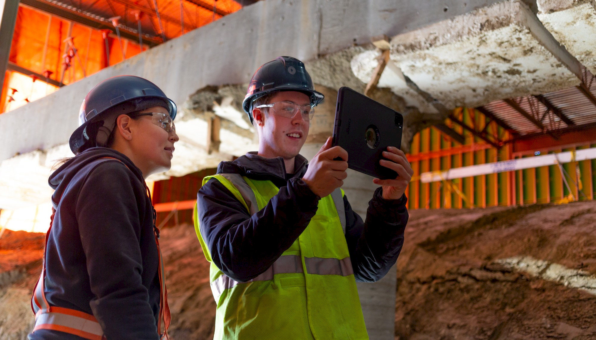 Image of two construction workers working together using a tablet to show clash detection on a Chandos Construction site in Alberta