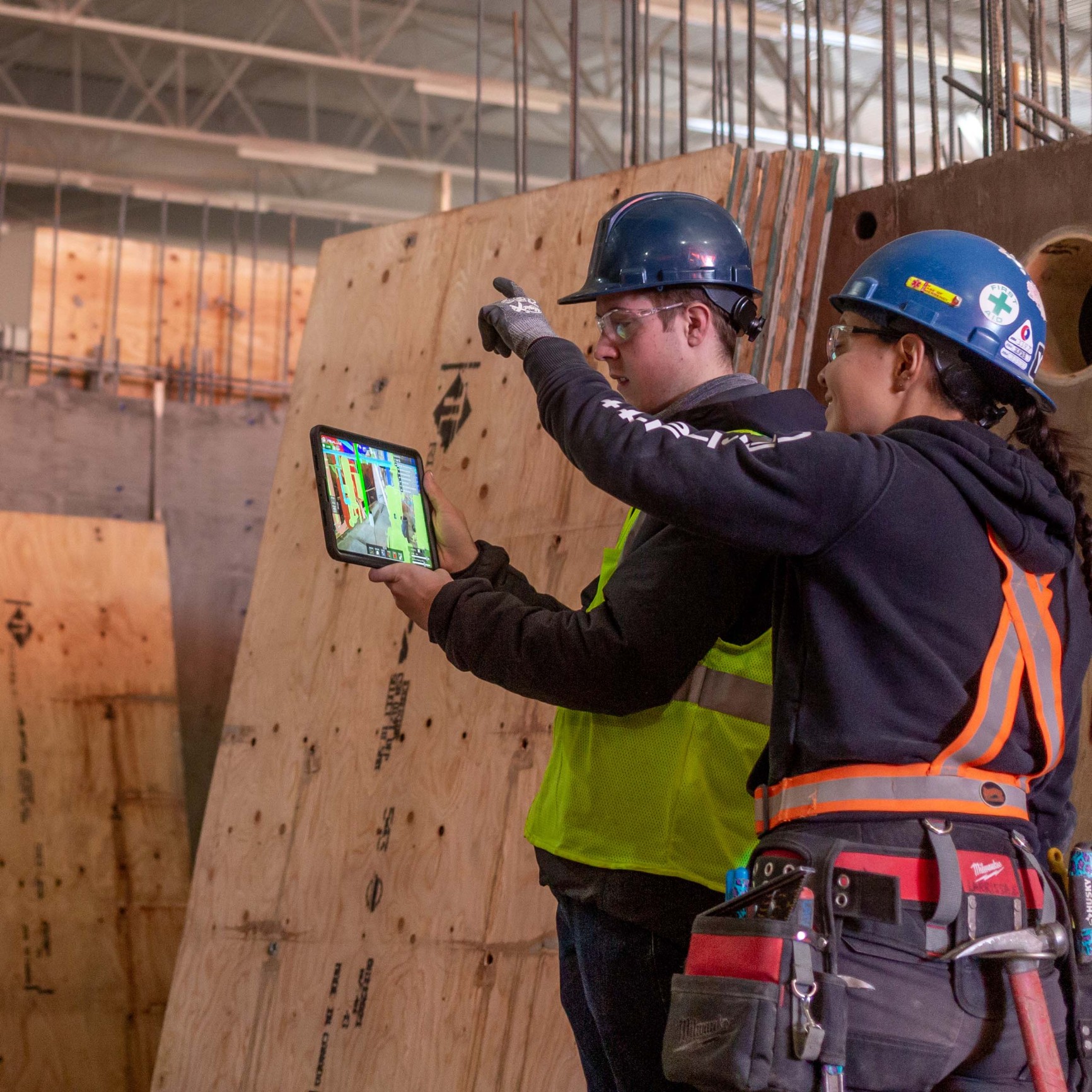 Image of two construction workers working together using a tablet to show clash detection on a Chandos Construction site in Alberta
