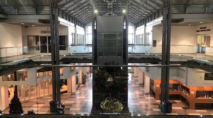 Interior shot of the Westland Market Mall, showcasing the glass hand railing on the perimeter of the 2nd floor mezzanine, installed by Chandos Construction Edmonton